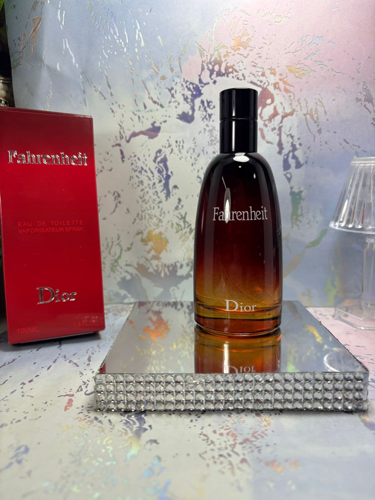 Perfume Dior Fahrenheit EDT 100ml con frasco degradado ámbar y caja roja sobre base espejo de cristales — catálogo designer Kikluxe que los revendedores de perfumes árabes usan para diversificar, precios mayoristas desde $95.000 COP con dropshipping a toda Colombia
