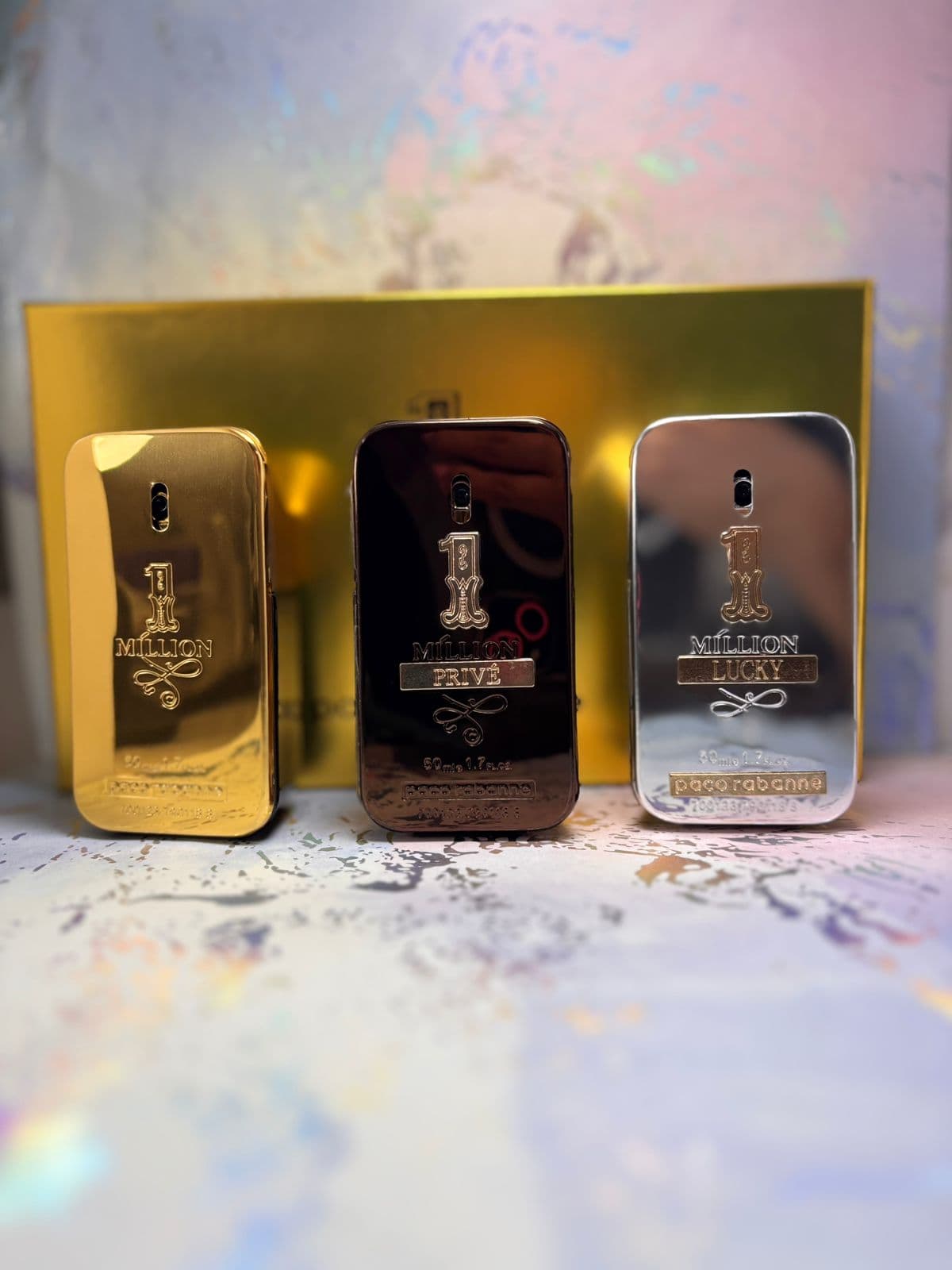 Perfumes premium dorados del catálogo Kikluxe Colombia 2026: trío Paco Rabanne 1 Million lingote dorado, 1 Million Privé y 1 Million Lucky con caja de regalo dorada — el segmento de lujo que acompaña al Ombre Nomade Louis Vuitton, precios mayoristas desde $125.000 COP con envíos 24-48h