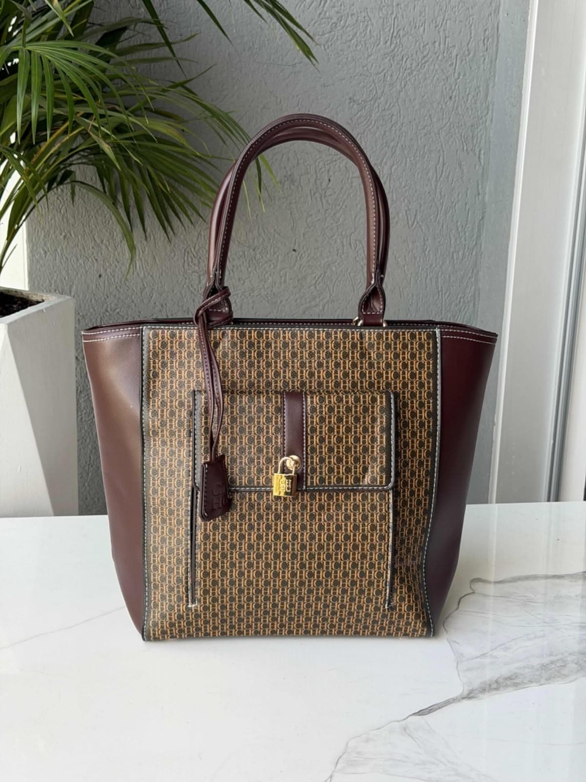 Bolsos al por mayor Colombia 2026: tote Carolina Herrera monogram CH vinotinto con candado dorado desde $90.000 COP — Kikluxe bodega de bolsos importados Triple AAA, envíos 24-48h a 13 ciudades sin mínimo de compra