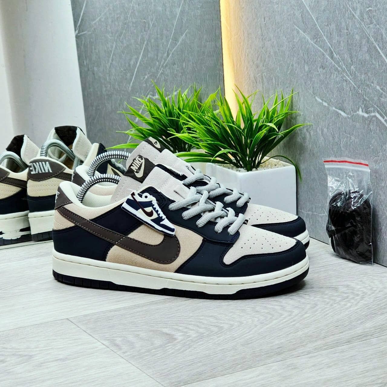 Nike Dunk Low azul marino y crema con swoosh café Colombia 2026 — triple AAA desde $90.000 COP, Kikluxe mayorista Medellín Bogotá Cali envíos sin mínimo dropshipping streetwear